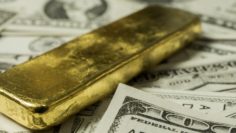 Close up image of dollar bill with gold bar
